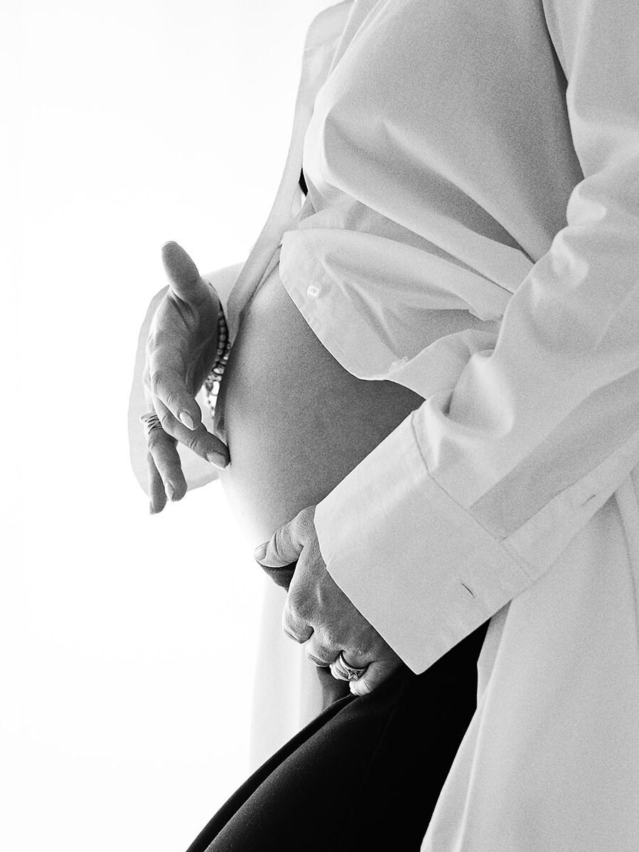 Fotografa a Vanzago - Immagine in bianco e nero, di una dobba che si tocca la pancia durante la gravidanza